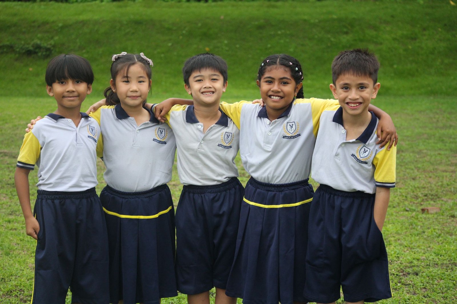 Lima peserta didik Sekolah Rahai berpelukan bersama di lapangan sekolah