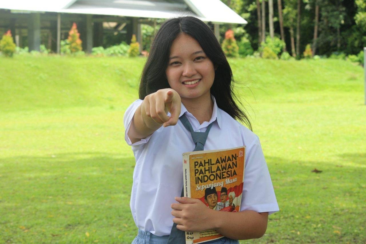 Siswi memegang buku Pahlawan-Pahlawan Indonesia